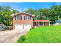 Two-story brick home with a well-manicured lawn, two-car garage, and covered porch at 2117 Chestnut Hill Circle Cir, Decatur, GA 30032
