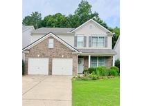 Charming two-story home features a brick facade, attached two-car garage, and beautifully landscaped front yard at 167 Diamond Ridge Ave, Canton, GA 30114