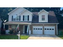 Charming two-story home with a brick facade, covered porch, and two-car garage at 1793 Cutters Mill Way, Lithonia, GA 30058