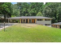 Charming single-story home featuring a covered carport and a large, lush front yard at 6456 Wright Ne Rd, Atlanta, GA 30328