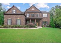 Beautiful brick two-story home featuring well-manicured landscaping and charming shutters at 4547 Meadow Green Nw Ln, Acworth, GA 30101
