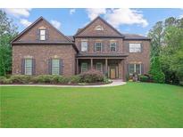 Inviting brick two-story home featuring manicured lawn and symmetrical architectural details at 4547 Meadow Green Nw Ln, Acworth, GA 30101