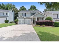 Charming two-story home with a well-manicured lawn and a spacious driveway leading to a two-car garage at 1609 Vinery Se Ln, Mableton, GA 30126