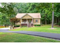 Charming single Gathering home featuring a quaint front porch with beautiful lawn and mature trees at 325 Harris Loop, Dallas, GA 30157