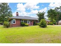 Charming brick home with a well-maintained lawn and mature trees at 1191 S Burnt Hickory Rd, Douglasville, GA 30134