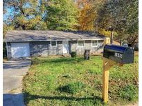 Charming single-story home with a manicured lawn and attached garage at 1946 Singer Way, Lithonia, GA 30058