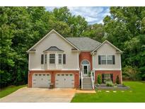 Charming two-story home with a well-manicured lawn and two-car garage nestled among mature trees at 40 Legend Creek Chase, Douglasville, GA 30134