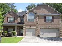 Charming two-story brick home featuring a manicured front yard and a two-car garage at 5896 Cliftondale Dr, Atlanta, GA 30349