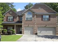 Charming two-story brick home featuring a two-car garage and manicured landscaping at 5896 Cliftondale Dr, Atlanta, GA 30349