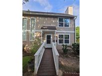 Inviting two-story home with a wooden walkway leading to the front door and a well-maintained yard at 1297 Tree Creek Ct, Clarkston, GA 30021