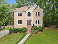 Charming two-story home featuring a landscaped yard and welcoming entrance, nestled in a lush, wooded area at 4771 Summerwood Se Dr, Smyrna, GA 30126