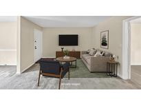 Cozy living room featuring a plush sofa, stylish decor, and a large TV at 58 Monet Nw Ct, Atlanta, GA 30327