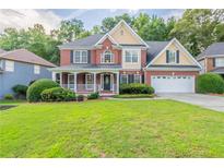 Charming two-story brick home with a welcoming front porch and well-manicured lawn at 1172 Oakhurst Trl, Lawrenceville, GA 30043