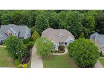 Beautiful home with well-manicured lawn, mature trees, a long driveway, and a three-car garage at 130 Holly Reserve Pkwy, Canton, GA 30114