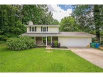 Traditional two-story home featuring a landscaped front yard and attached garage at 5868 Kingswood Nw Ct, Norcross, GA 30093