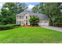 Beautiful two-story home with manicured lawn, attached two car garage, and mature trees at 121 Clipper Bay Drive, Alpharetta, GA 30005