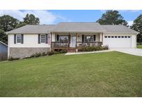 Charming single-story home featuring a welcoming front porch and well-manicured lawn at 1250 Timber Walk Dr, Loganville, GA 30052
