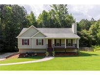 Charming single-story home with a well-maintained lawn, inviting porch, and colorful landscaping at 19 Autumn Ne Pl, White, GA 30184