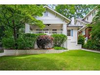 Charming white brick home featuring a well-maintained lawn and front porch at 626 Elmwood Ne Dr, Atlanta, GA 30306