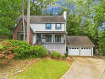 Charming two-story home with a brick accent, a front porch, an attached garage, and a beautiful landscaped yard at 200 Zachary Woods Nw Pt, Marietta, GA 30064