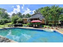 Inviting backyard pool with lounge chairs and umbrella, perfect for relaxing and entertaining outdoors at 4562 Lucerne Valley Sw Rd, Lilburn, GA 30047
