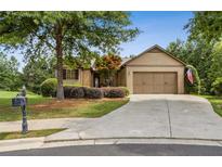 Charming one-story home with manicured lawn, mature trees, and two-car garage at 601 Laurel Xing, Canton, GA 30114