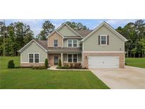 Charming two-story home with a mix of brick and siding, complemented by a well-manicured lawn at 2 Whites Pond Rd, Moreland, GA 30259