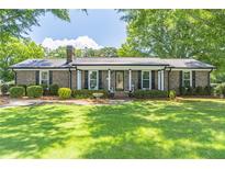 Charming brick ranch home with a metal roof and manicured front lawn at 3152 H D Atha Rd, Covington, GA 30014