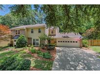 Charming two-story home with a brick and siding exterior and a well-manicured front yard, including a two car garage at 4477 Village Dr, Atlanta, GA 30338