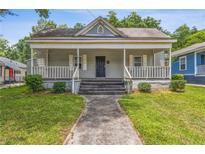 Charming home featuring a covered front porch and a well-maintained lawn at 1365 Athens Sw Ave, Atlanta, GA 30310