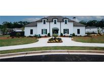 Elegant white brick home featuring a well-manicured lawn, symmetrical landscaping, and a charming entryway at 3579 Silvery Way, Powder Springs, GA 30127