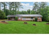 Charming brick home with a spacious front yard and mature trees offers classic curb appeal at 1913 Ferry Dr, Marietta, GA 30066