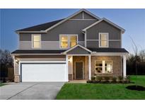 Two-story home featuring a two-car garage, brick facade, manicured lawn, and welcoming entryway at 1921 Fairchild Ln, Grayson, GA 30017