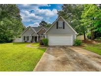 Charming single-Gathering home with a well-maintained lawn and attached two-car garage at 556 Walton Dr, Social Circle, GA 30025