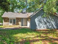 Quaint single-story house featuring stone facade and gray wood paneling at 8685 Woodside Ln, Jonesboro, GA 30238