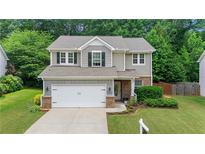 Charming two-story home with a well-manicured lawn and a two-car garage in a suburban neighborhood at 4020 New Salem Ct, Cumming, GA 30040
