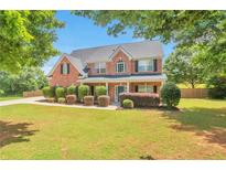 Charming two-story brick home with a well-manicured lawn and mature trees at 1504 Terminal Ct, Mcdonough, GA 30252