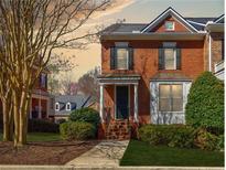 Inviting brick two-story townhome with landscaped front yard and walkway to a covered front door at 5210 Davenport Pl, Roswell, GA 30075
