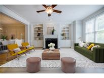 Bright living room featuring fireplace, built-in shelves, large windows, modern furniture, and an open floor plan at 5210 Davenport Pl, Roswell, GA 30075