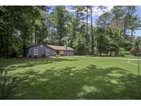 Charming single-story home with blue siding, red shutters, and a lush green lawn at 539 Karen Dr, Alpharetta, GA 30009