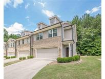 Charming townhome with brick accents, two-car garage, and well-manicured lawn at 3291 Wild Basil Ln, Buford, GA 30519