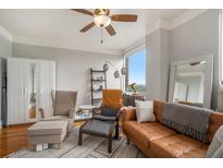 Inviting living room with hardwood floors, ceiling fan, and a comfortable leather sofa at 75 Ponce De Leon Ne Ave # 1004, Atlanta, GA 30308