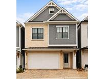 Charming two-story home featuring stone and gray shingle siding, a two-car garage, and a welcoming front door at 114 Batten Board Way, Woodstock, GA 30189