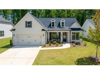 Charming white brick home with black trim, a well-manicured lawn and a welcoming front porch at 313 Sobeck Way, Canton, GA 30115