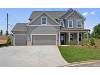 Charming two-story home featuring a gray exterior, well-manicured lawn, and an attached two-car garage at 6934 Melody Ridge Rd, Buford, GA 30518