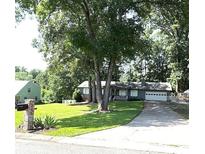 Charming single-story home with a two-car garage, surrounded by mature trees and a well-manicured lawn at 205 Trickum Hills Ln, Woodstock, GA 30188