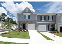 Two-story townhome features a one-car garage and manicured lawn at 3554 Bluebird Ct, Atlanta, GA 30331