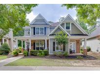 Charming two-story home with a welcoming front porch and manicured landscaping at 3900 Baluster Ct, Suwanee, GA 30024
