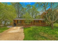 Charming brick home featuring a welcoming front porch and lush green lawn at 4225 Parkridge Dr, Powder Springs, GA 30127
