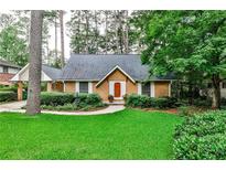 Charming single-story home with a brick facade, lush landscaping, and a well-manicured green lawn at 1338 Talcott Pl, Decatur, GA 30033